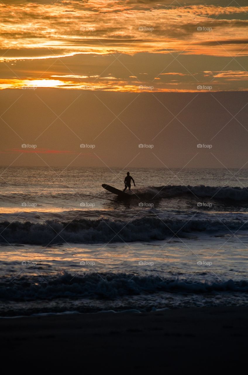 After rising early to take some beach sunrise photos, I noticed a lone surfer silhouetted against the morning sky.