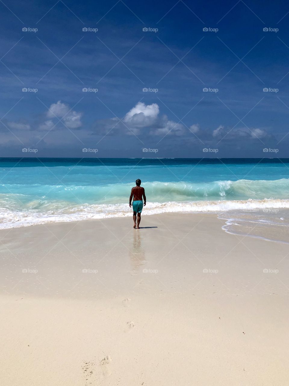 Man walking into ocean at beach