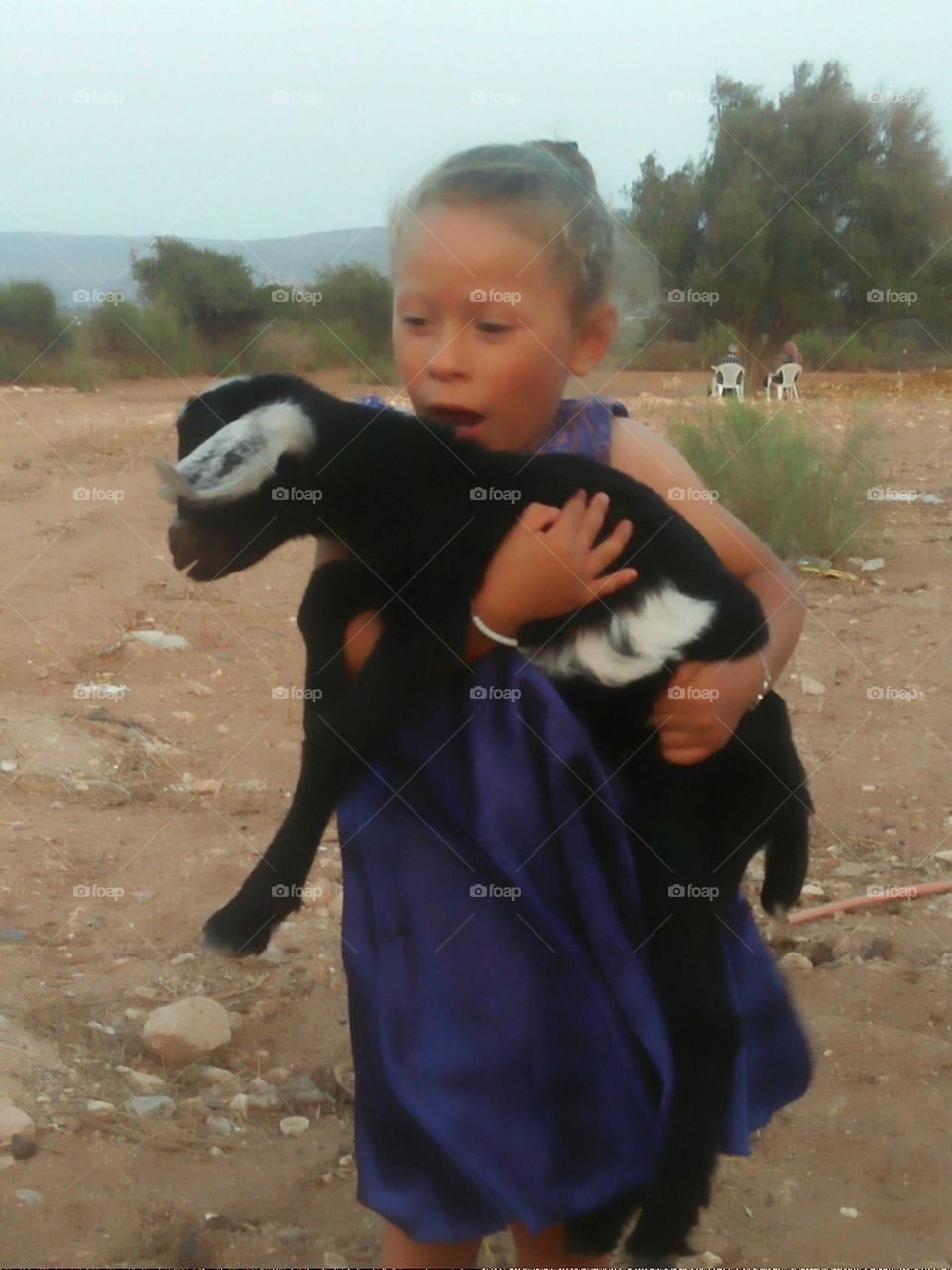 Beautiful girl holding a baby goat.