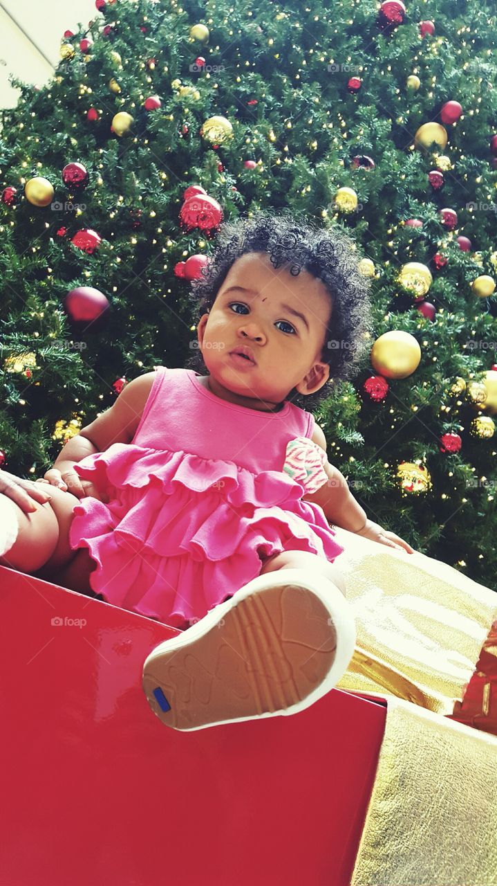 African baby sitting under the christmas tree