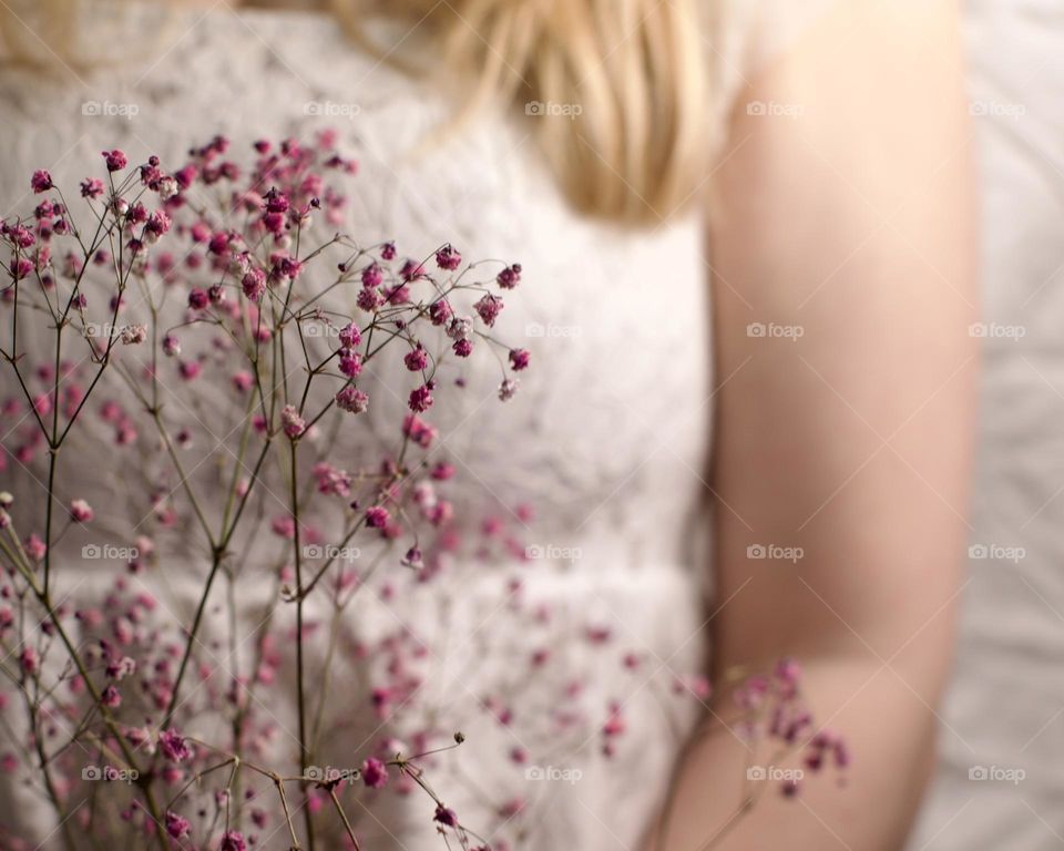 Woman in lace holding pink baby’s breathe