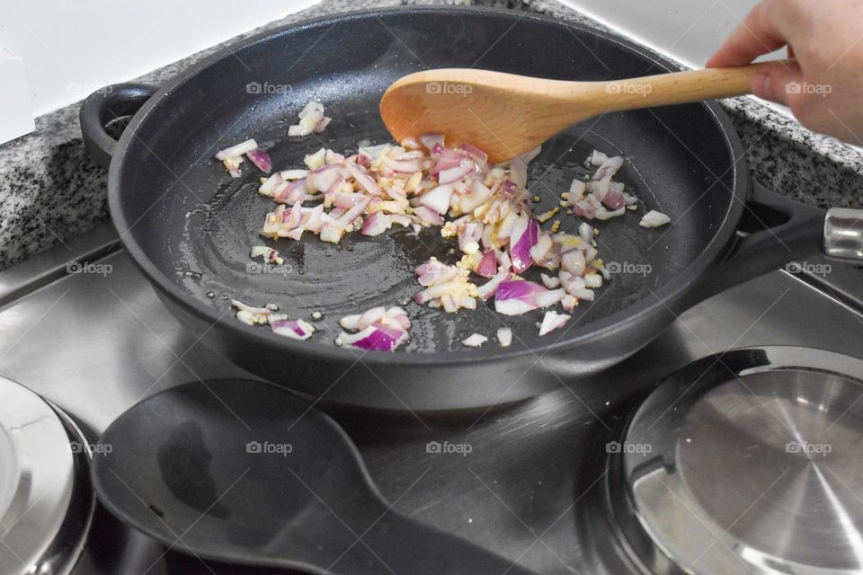 Homecooking cooking Frittata at home and adding and mixing ingredients and removing the Frittata from the pan for cutting and serving on a white plate with tomatoes. Healthy home cooking in kitchen. Breakfast and lunch food preparation.