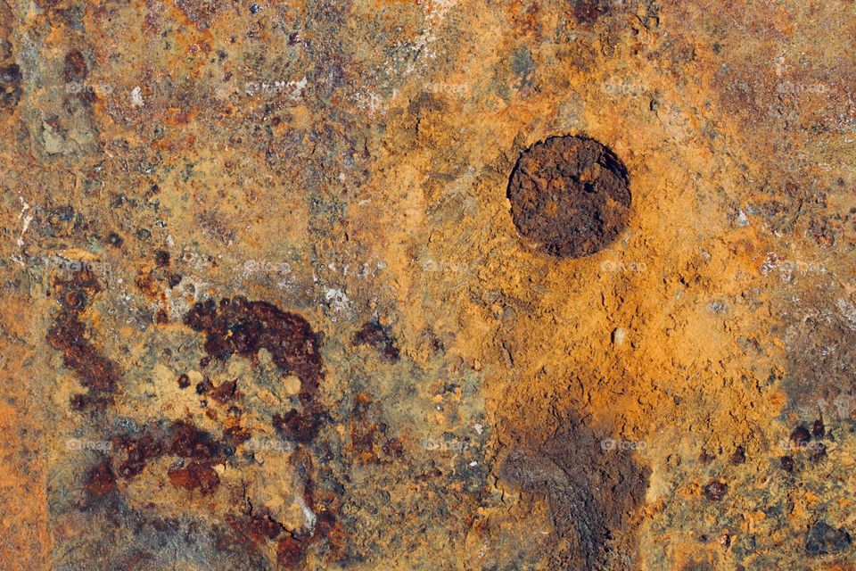 Rusted, corroded metal with a flat rivet