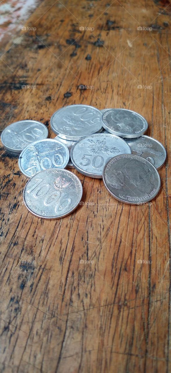 Rupiah coins on an ancient wooden table