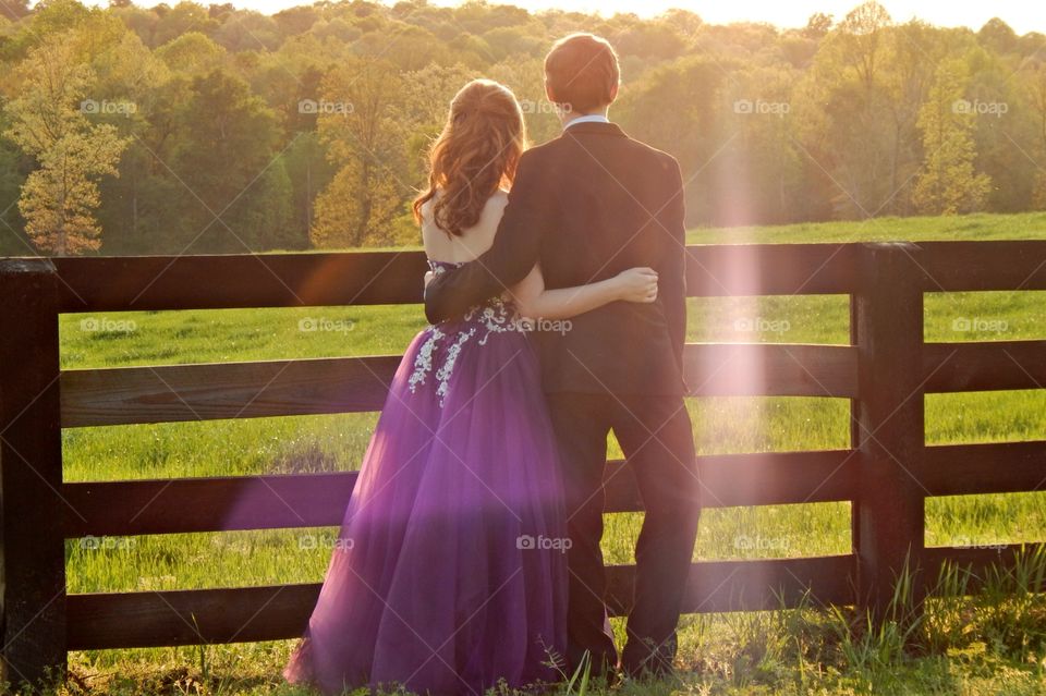 young couple posing in a county setting before prom.