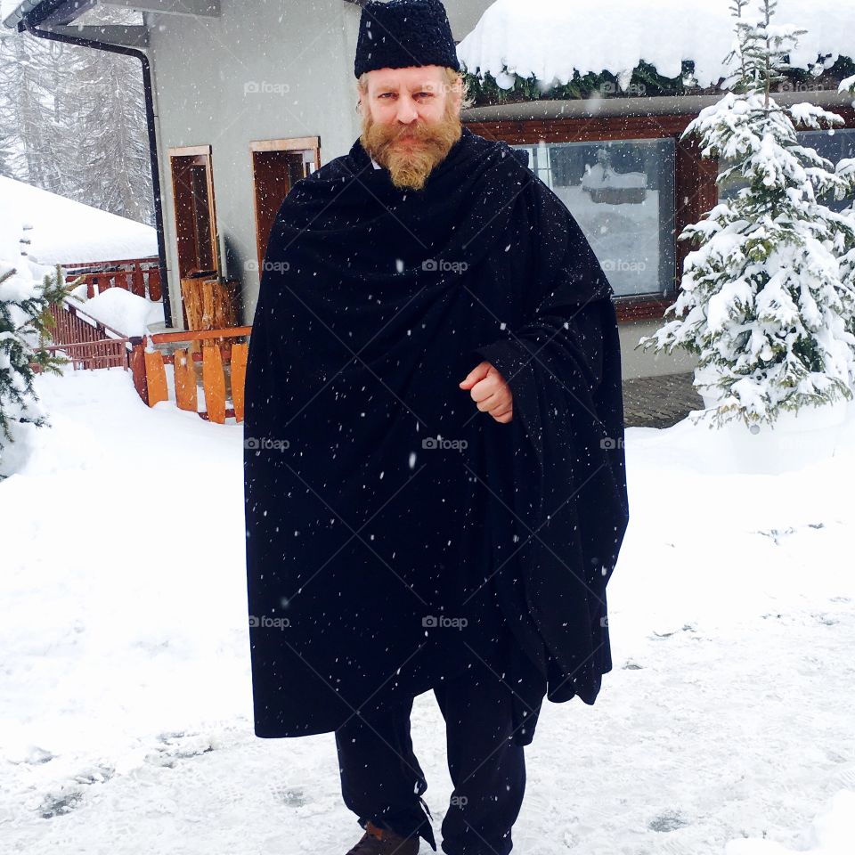 Snowing, a Man walking up the Road 