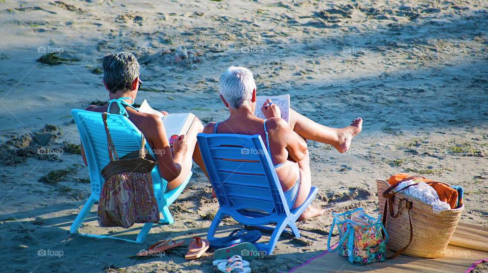 Two senior women relaxing at the beach