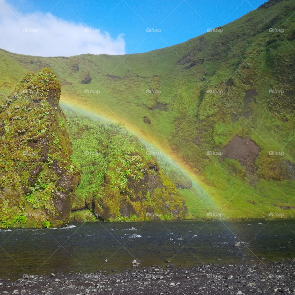 Rainbow hiding behind a small hill- Iceland