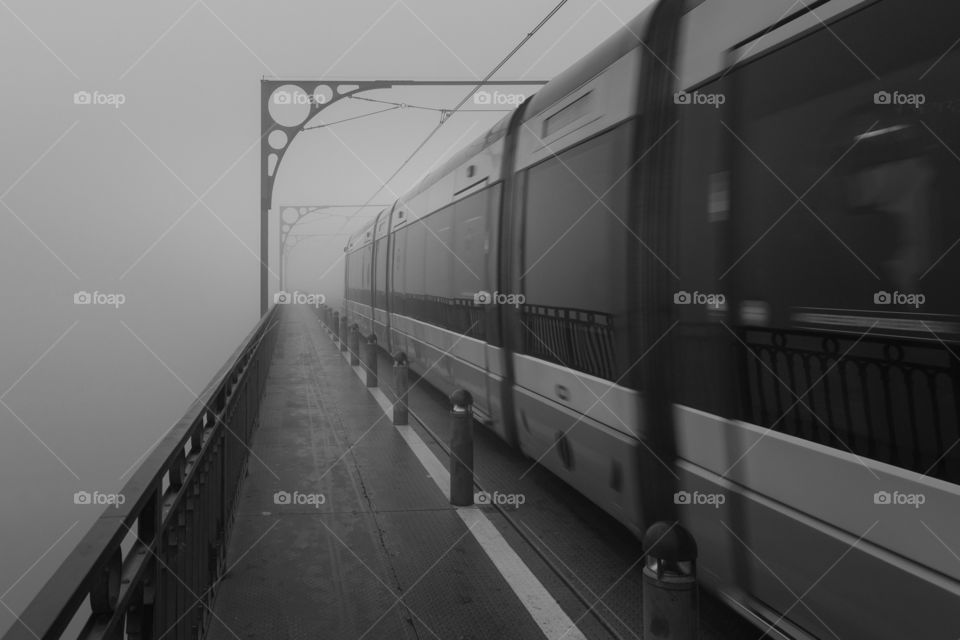 Tram disappearing in thick morning fog in Porto 