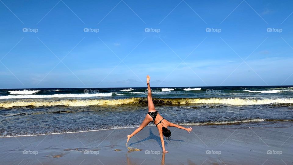 Child doing acrobatics on the beach