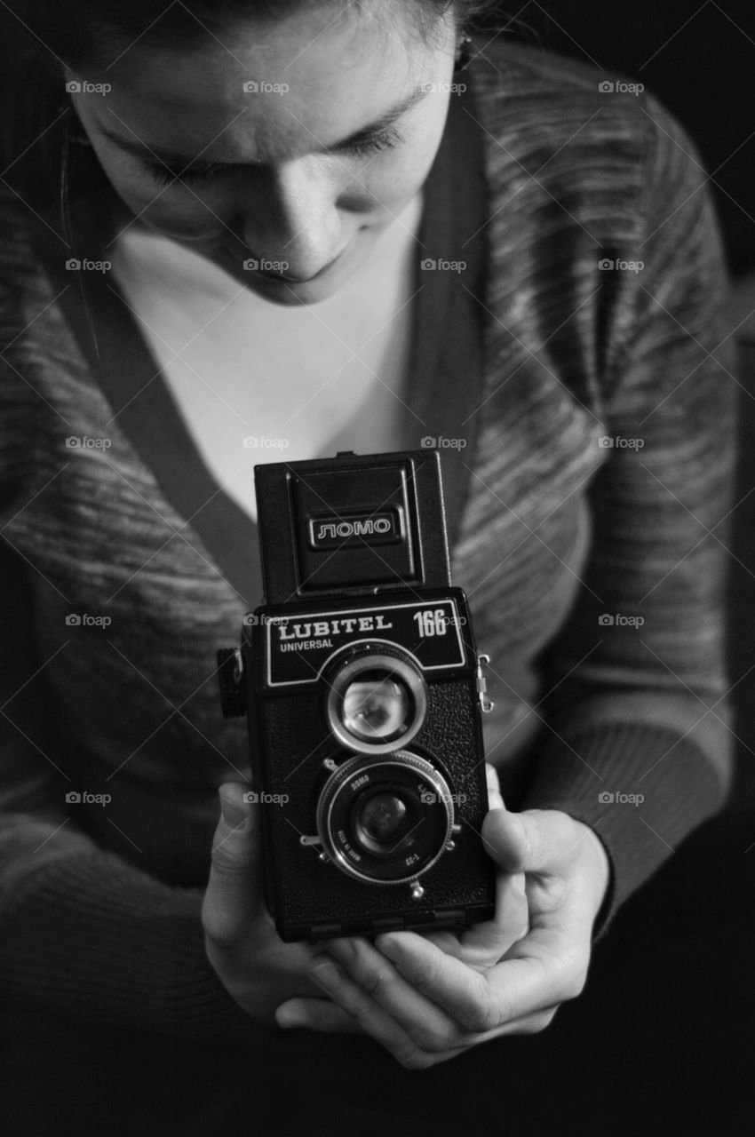 Young woman holding old camera. Young woman holding old film camera