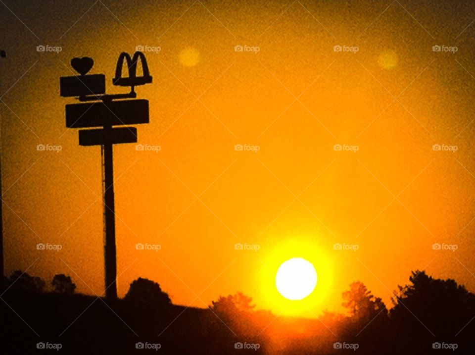 Sunrise on the road. McDonald's sign 