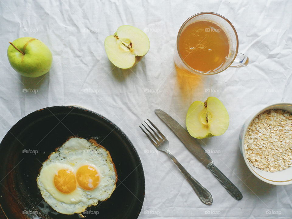 oatmeal,eggs,apples and green tea on the table