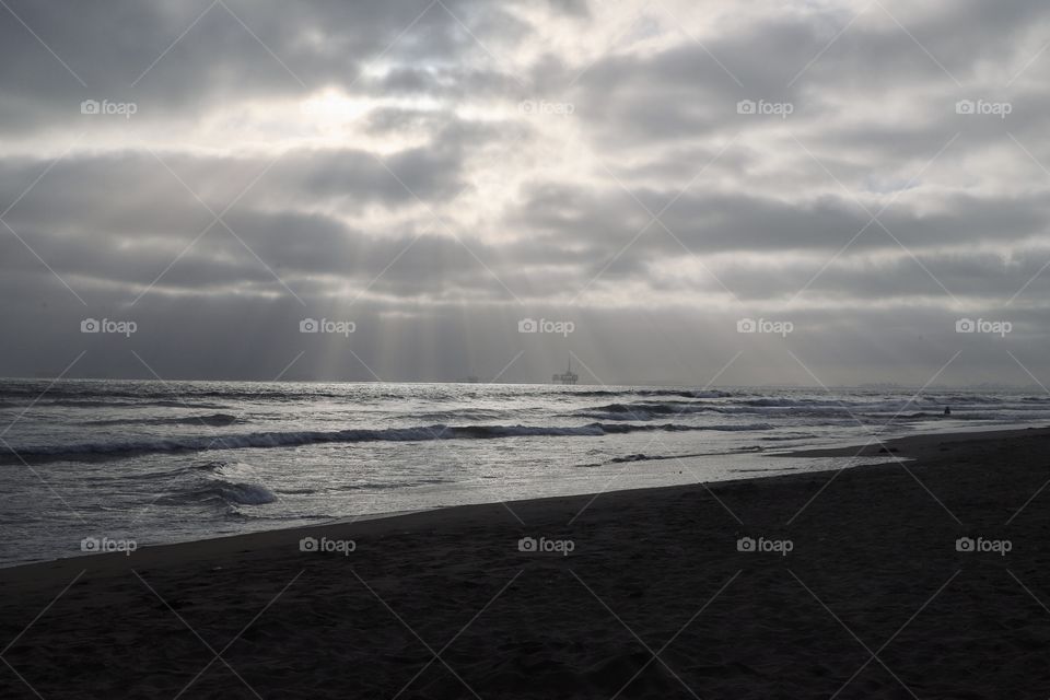 Sun poking through the clouds. Huntington Beach, California.