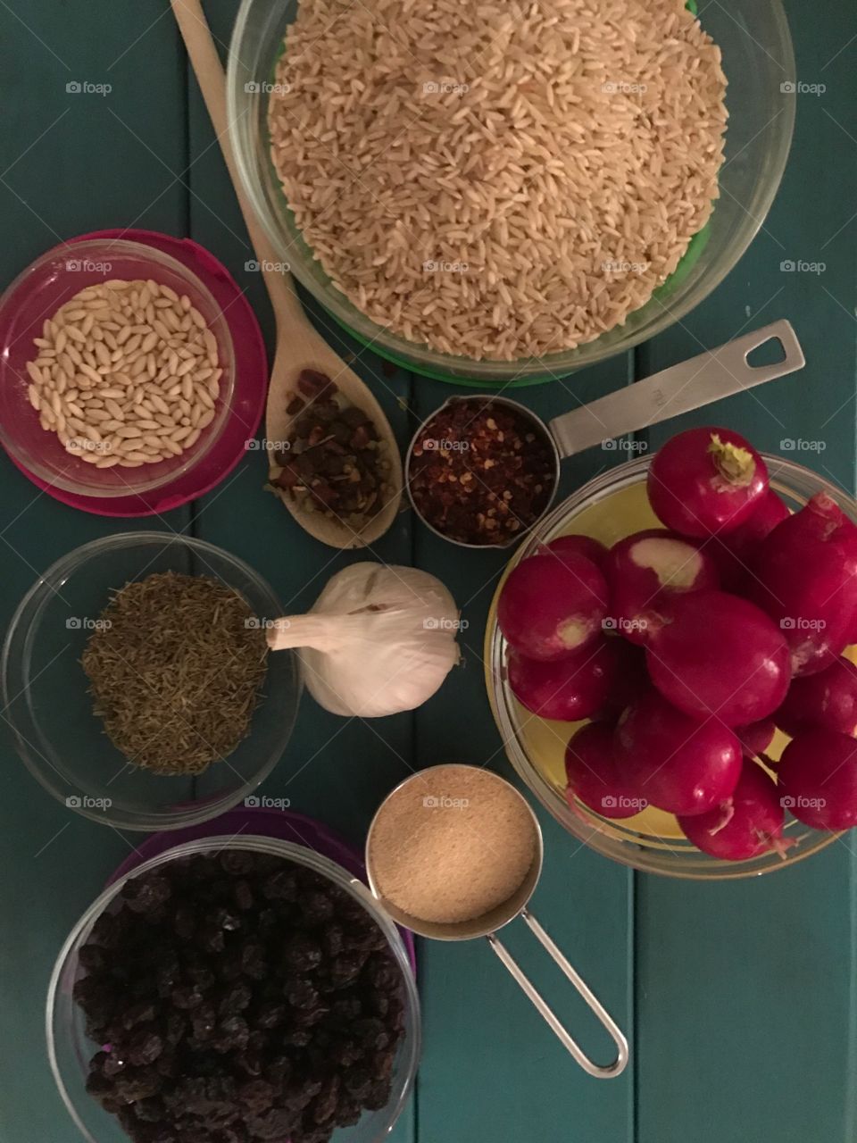 Preparing to cook with healthy ingredients such as dry brown rice, hot pepper spice, garlic powder and other fresh herbs and spices 