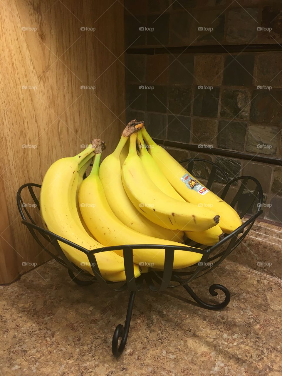 Bananas in an iron fruit bowl. 