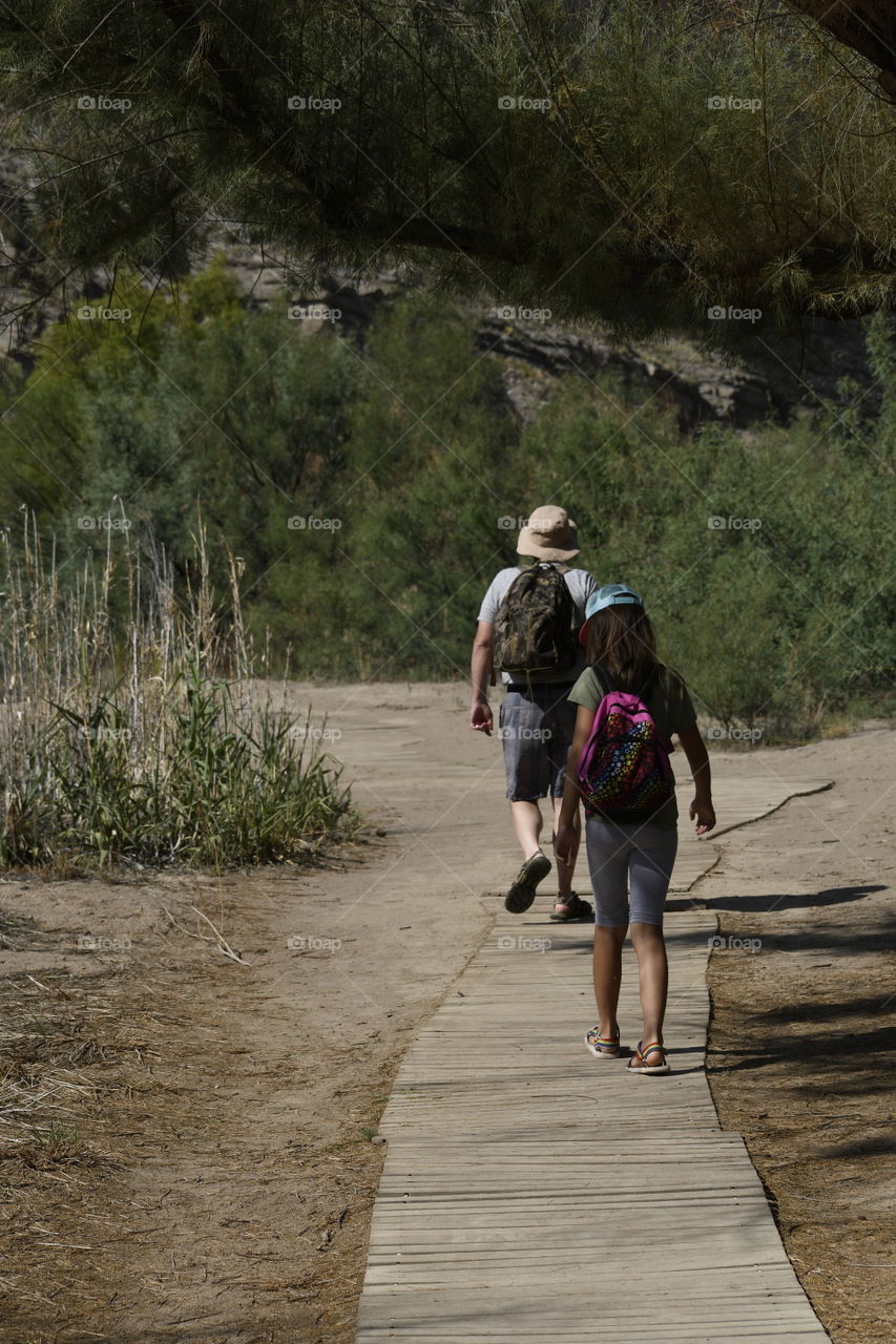 A child and an adult walking on a trail