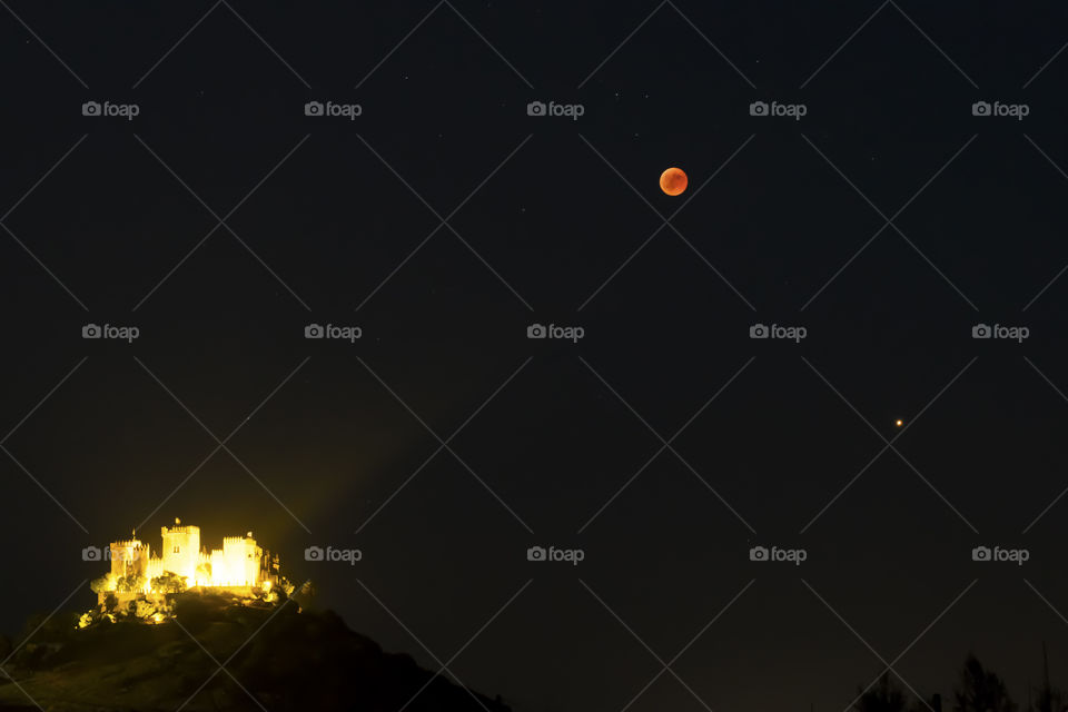 Blood moon over a castle in Spain