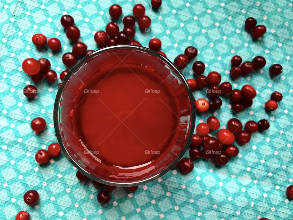 Red cranberry juice on blue textile background 