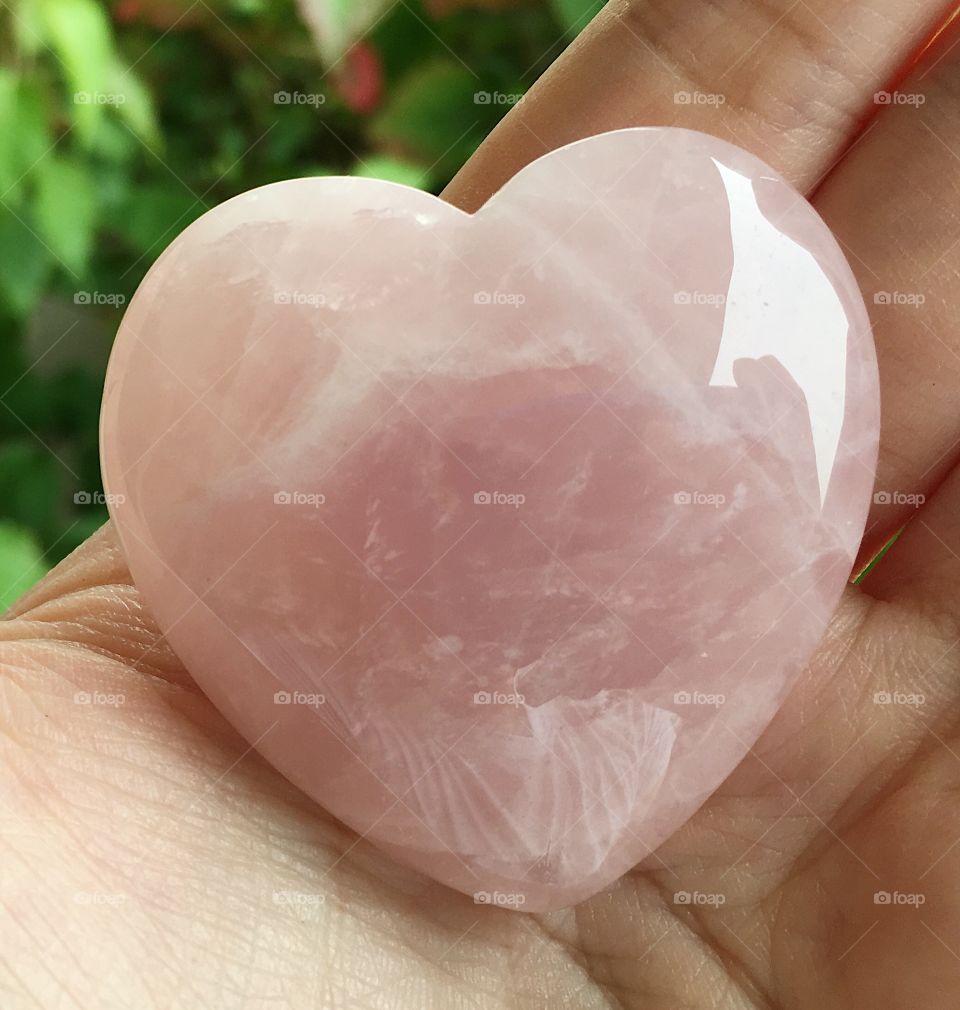 A pink heart-shaped rose quartz crystal.