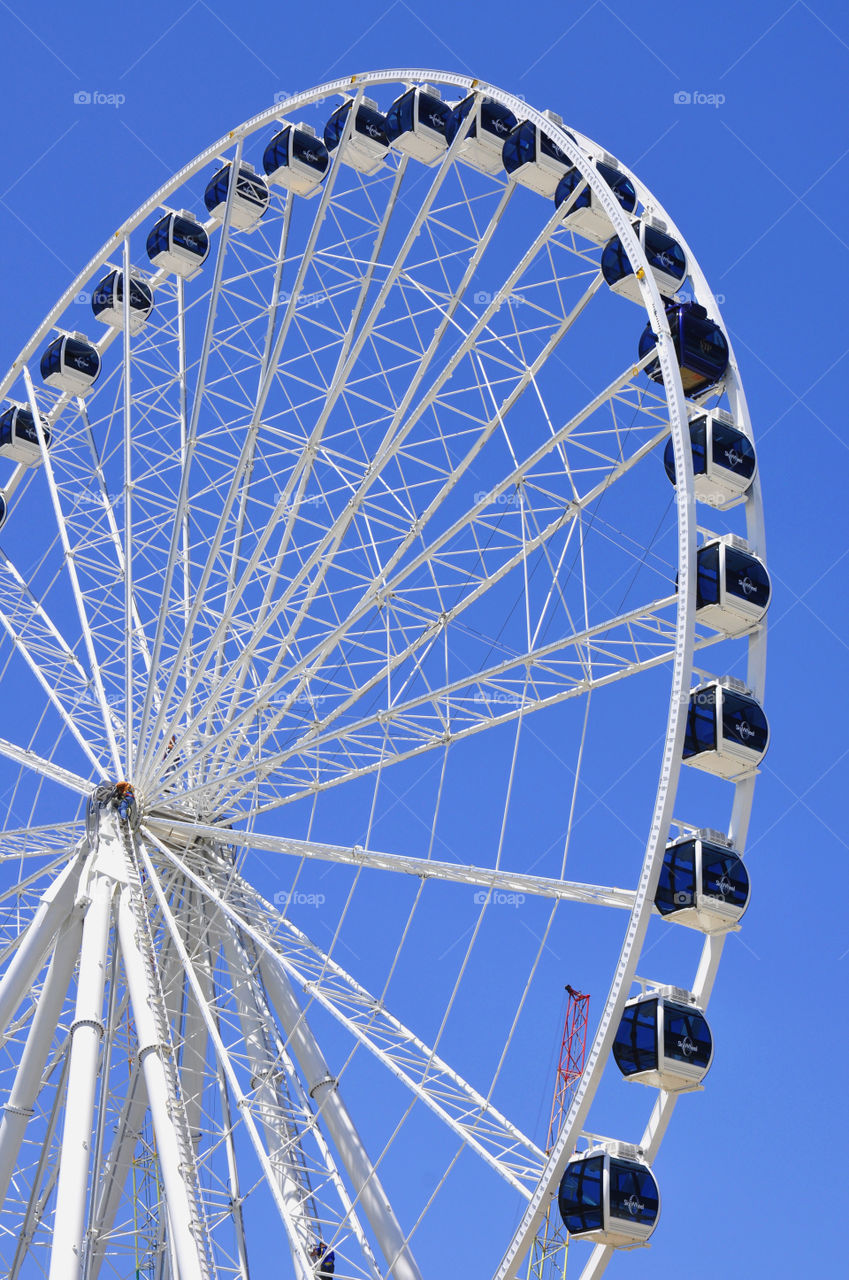 A Ferris wheel against a bright blue sky. 