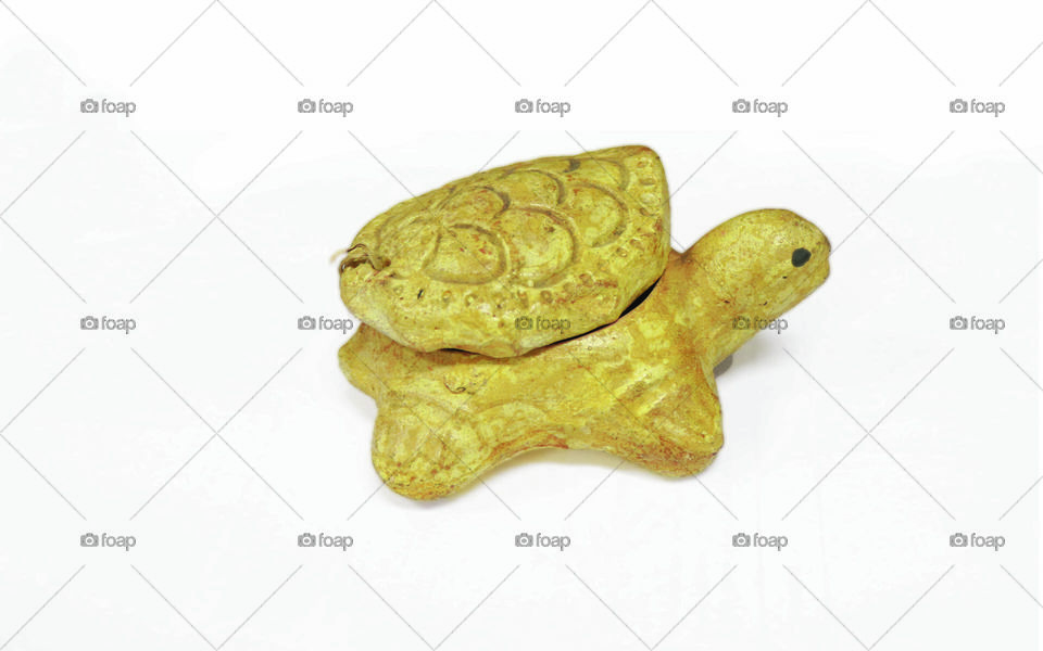 Photo of a turtle statue made of stone on a white background