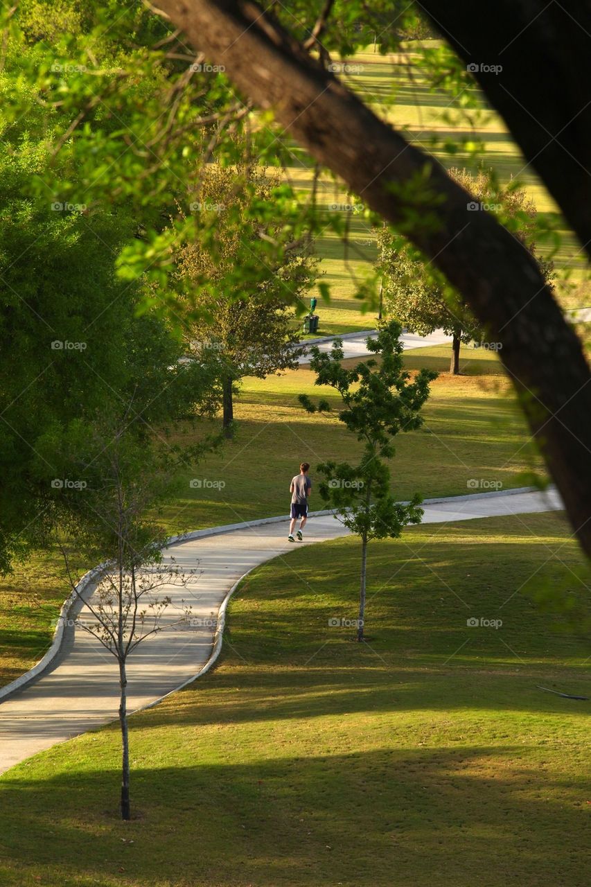 Young man jogging at golf course track