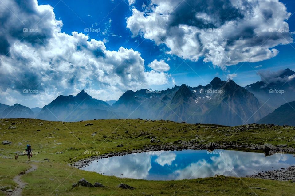 mountain landscape with hiker and dog, italian alps.