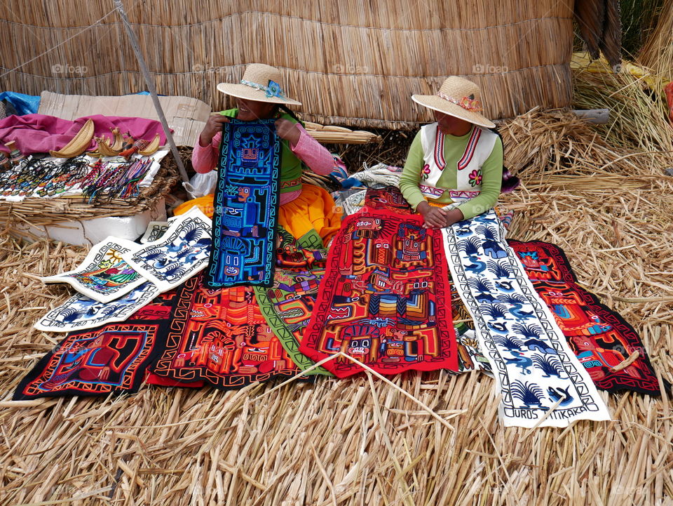 Two women selling colorful carpets