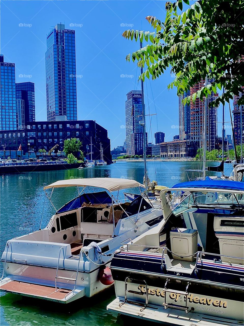 A beautiful idyllic scenery can be encountered here at “Newtown Creek” by the “Pulaski Bridge” in LIC, Queens with various boats tied up here and trees and grasses lining the shore. 2023. Hypnotic Productions