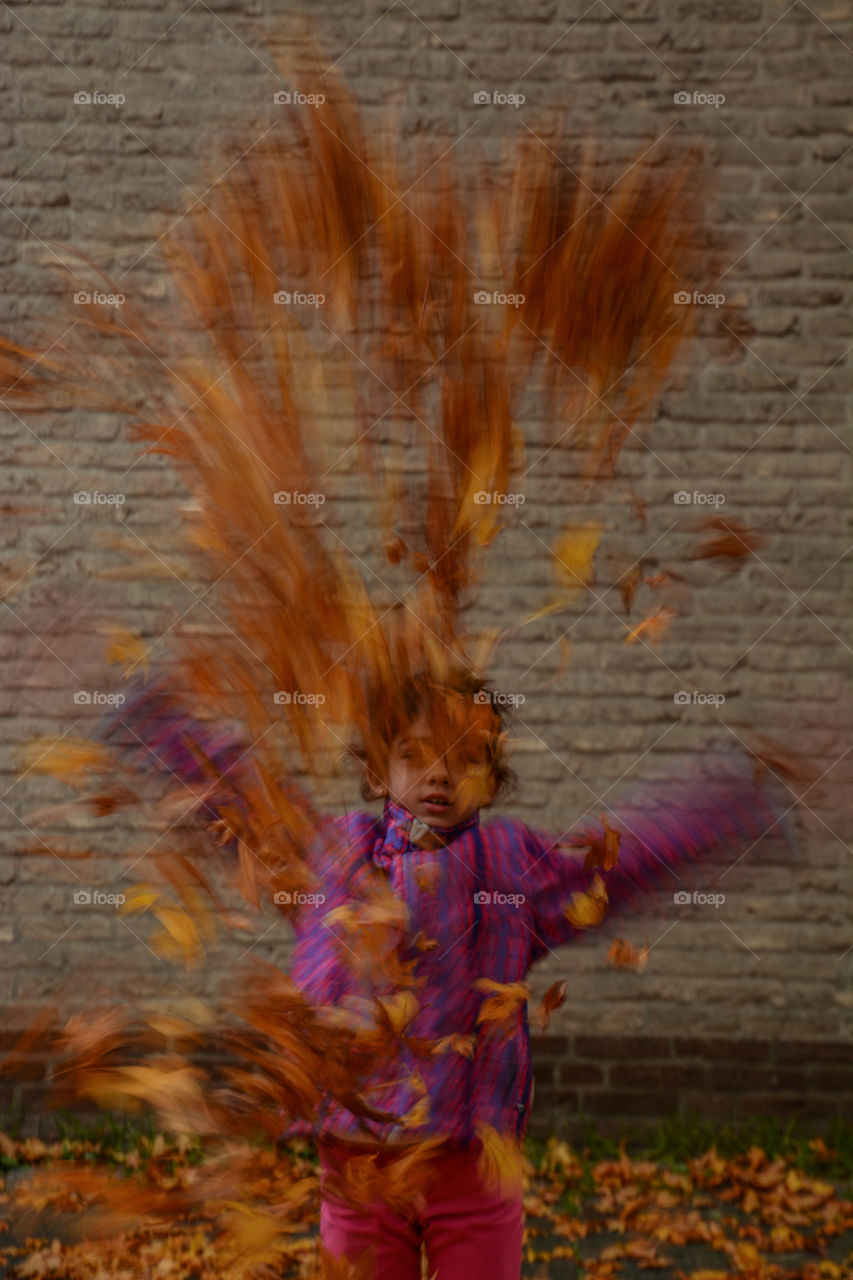 Little girl Throwing leaves up in the air