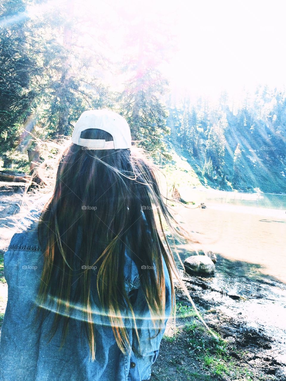 long hair with a hat and pines camping