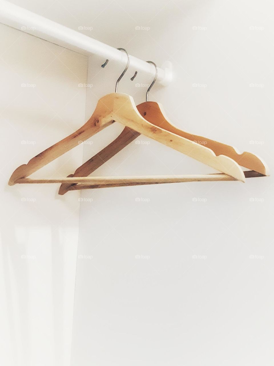 Close up brown wooden hanger hanging in the wardrobes isolated on white background.