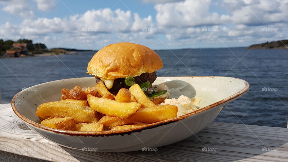 Having a hamburger and fries by the ocean 