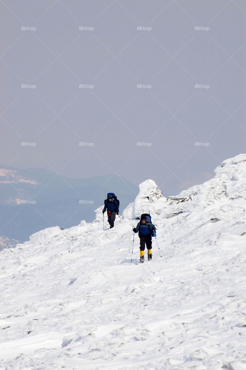 Backpackers crossing the frozen tundra on the summits of the White