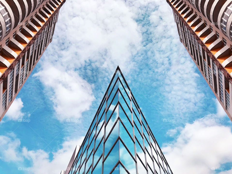 Top view of modern buildings in the city on blue cloudy sky background 