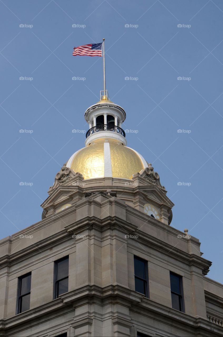 The flag fly's high atop city hall in downtown historic Savannah district of Georgia.