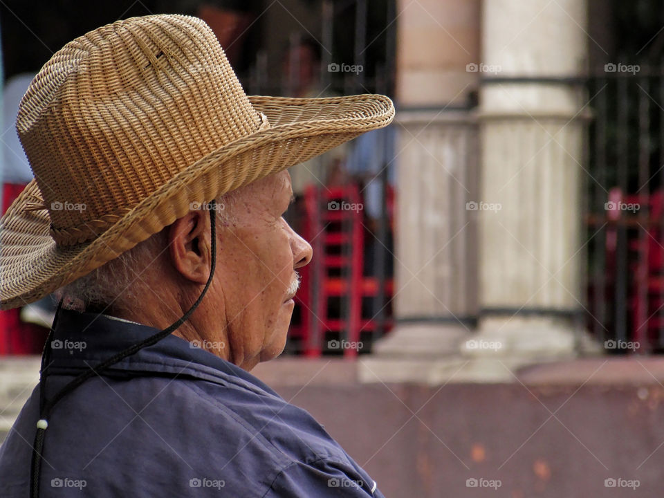 Man with traditional hand-crafted hat contemplating in the downtown area of San Miguel de Allende, Guanajuato, Mexico