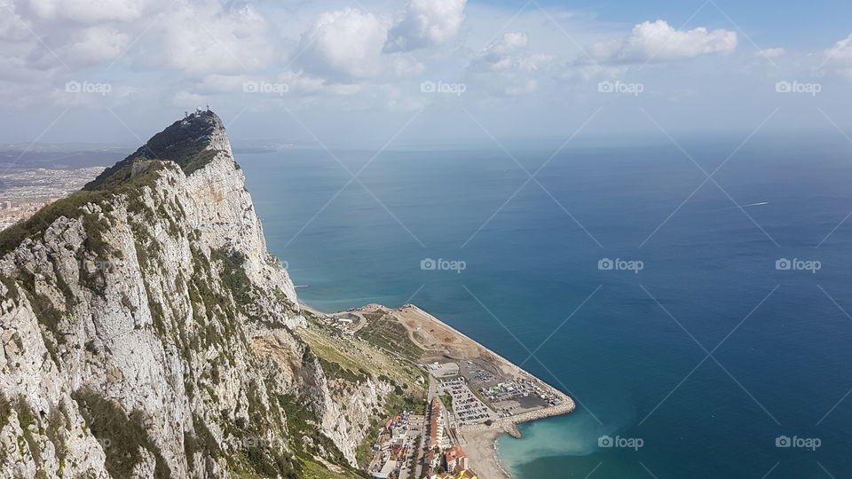 View from above, up high on The Rock of Gibraltar, Europe. Looking out towards ocean and blue sky.