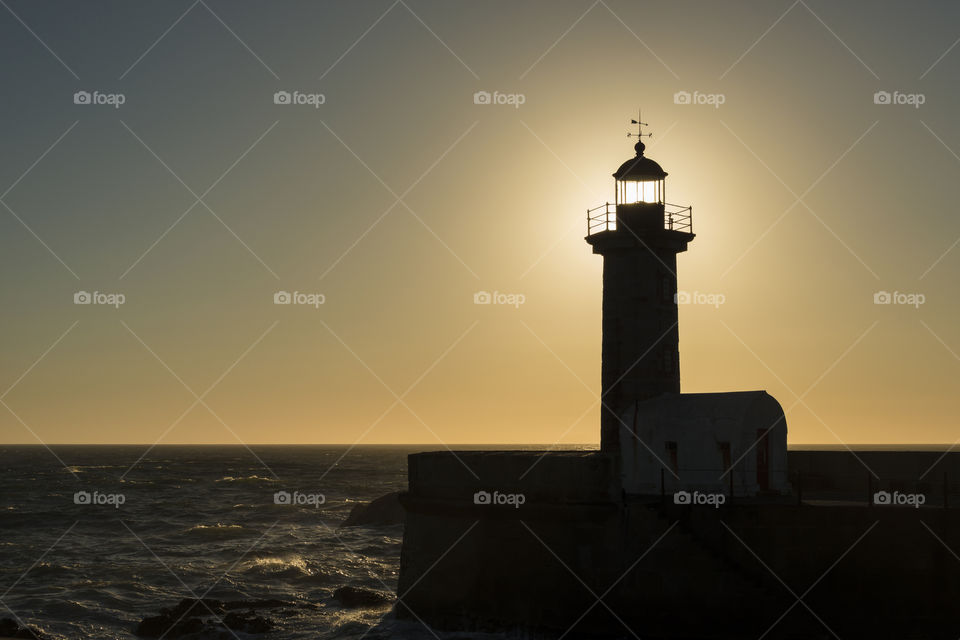 Sunset behind lighthouse in Porto - Portugal