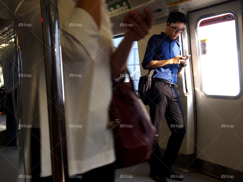 man using smartphone or cellphone inside a train