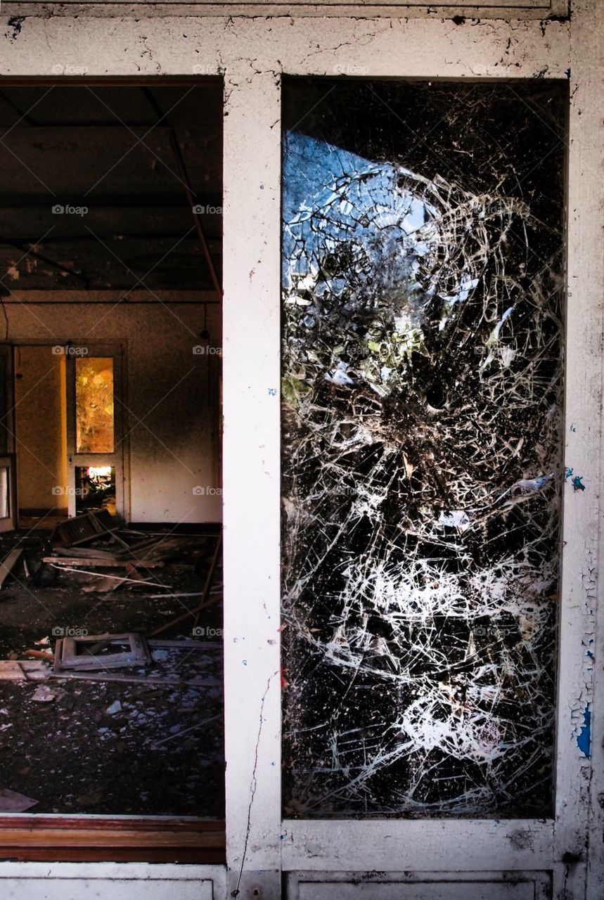 Shattered Window Looking Into An Abandoned Hotel