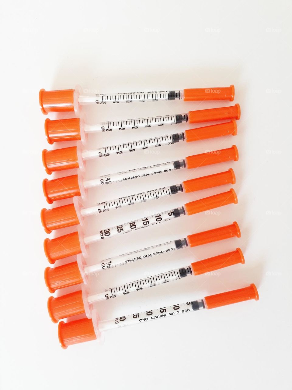 Syringes used to administer Insulin to a Type 2 Diabetic are laid out on white sheets.