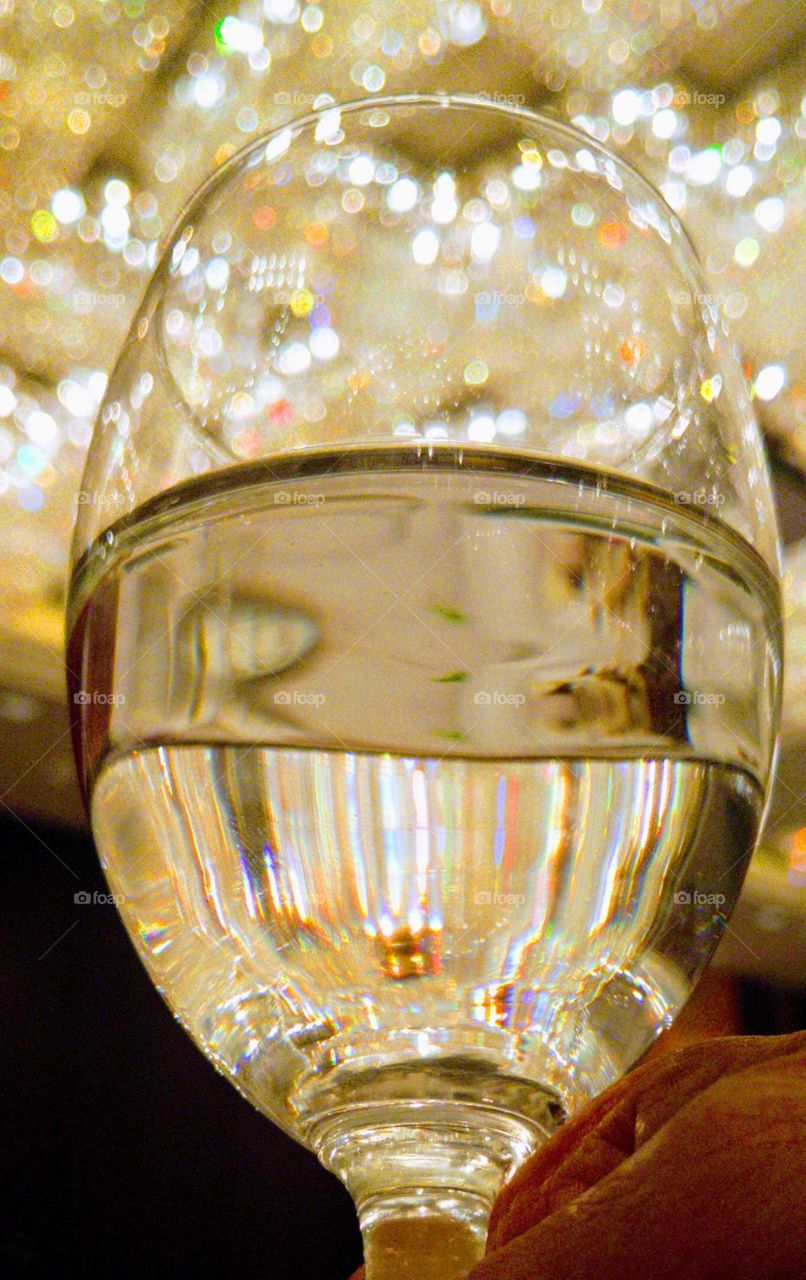 Color vs Black and White: the chandelier's reflection on the wine glass at dinner party. colors beautiful.