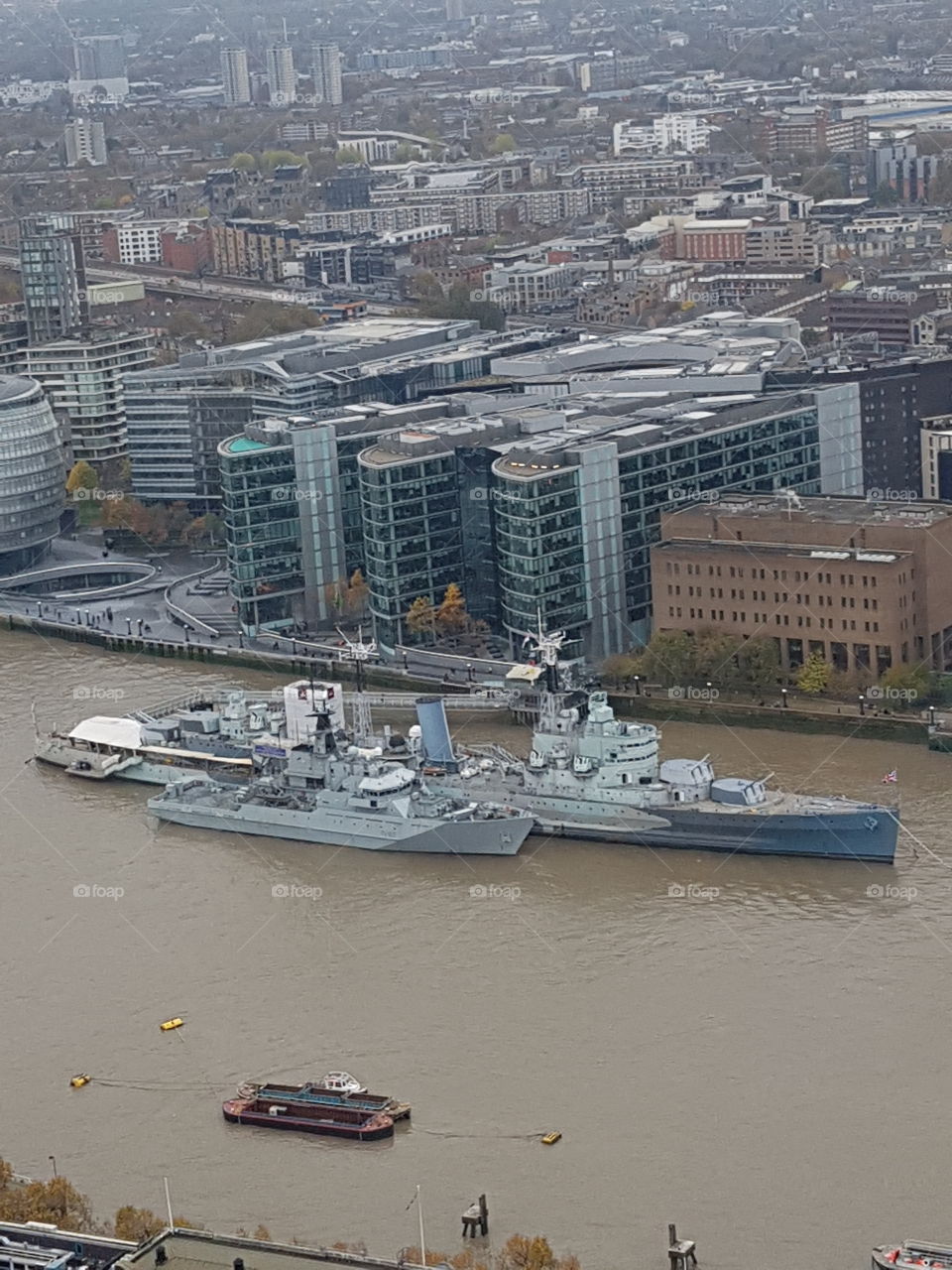 view of the battleship on the river Thames from the walkie talkie building
