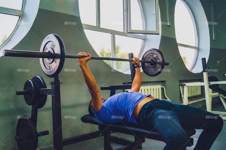 Guy exercising with a barbell in the gym