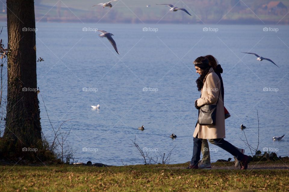 Couple Walking On Lake Shore