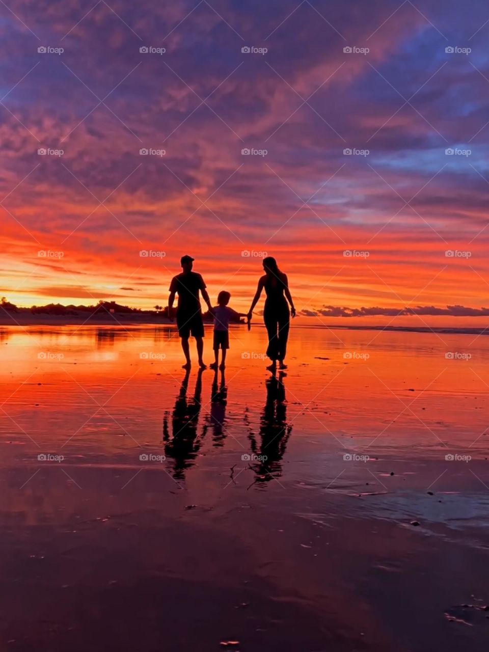 Family walking on the beach at sunset