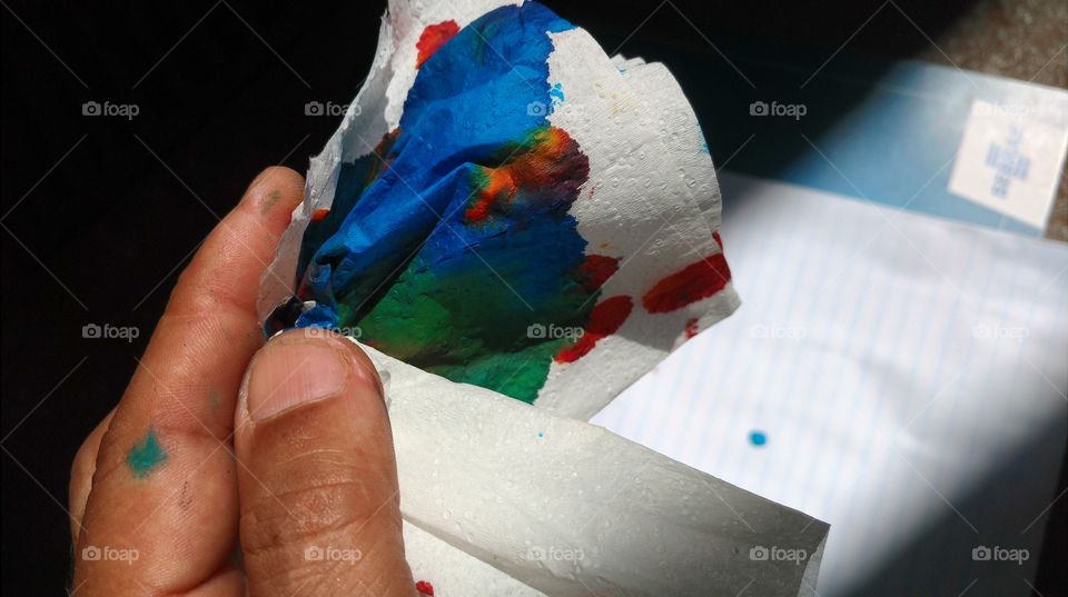 Mão e papéis, com belíssimas cores de tintas de impressoras.