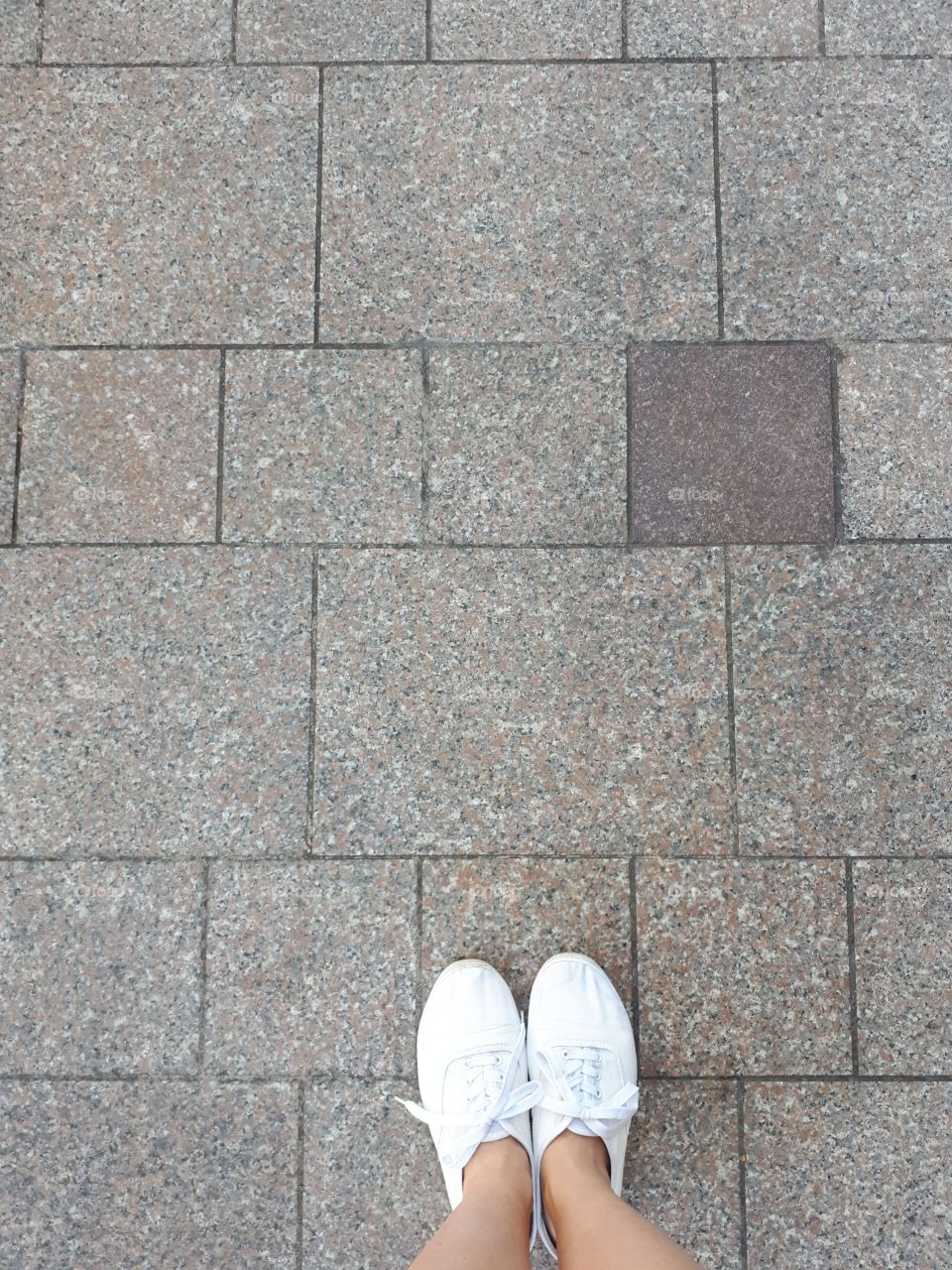 White moccasins at the grey granite tiles